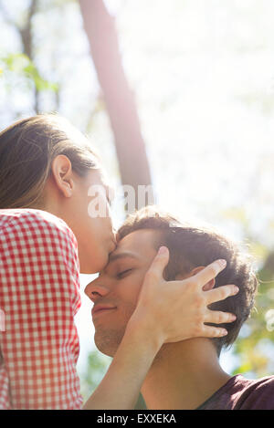 Couple ensemble à l'extérieur, woman kissing man's front Banque D'Images