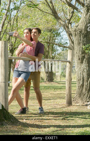 Couple posant pour un parc en selfies Banque D'Images