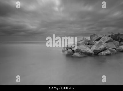 Beau paysage marin avec des brise-lames de pierre photographié sur une longue exposition. Banque D'Images