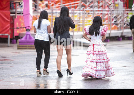 Pluie battante sur les jeunes femmes, certains portant des vêtements traditionnel de Séville à Séville, Andalousie, Espagne, Europe. Avril au festival Feria. Banque D'Images