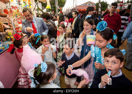 À Séville, Andalousie, Espagne, Europe. Manger de la barbe à papa à la juste à la section masse Feria avril Festival et sections locales de traditiona Banque D'Images