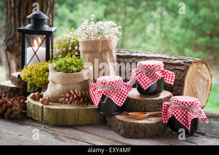 Nature morte avec pots de confiture de fruits, lampe vintage et décoration en style rustique. Banque D'Images