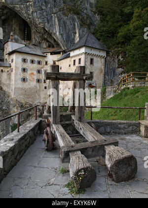 Catapulte en bois avec château de Predjama, un château renaissance construit dans une grotte, à l'arrière-plan, près de Postojna. La Slovénie. Banque D'Images