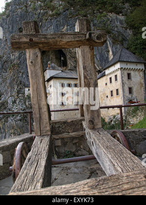 Catapulte en bois avec château de Predjama, un château renaissance construit dans une grotte, à l'arrière-plan, près de Postojna. La Slovénie. Banque D'Images