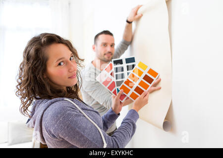 Vue d'un jeune couple à choisir des couleurs de leur papier peint Banque D'Images