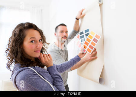 Vue d'un jeune couple à choisir des couleurs de leur papier peint Banque D'Images