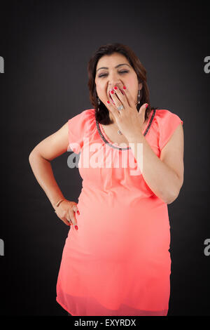 Belle femme faisant des expressions différentes dans différents ensembles de vêtements : bâillement Banque D'Images