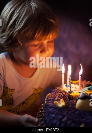 Petit garçon souffle les bougies pour son anniversaire Banque D'Images