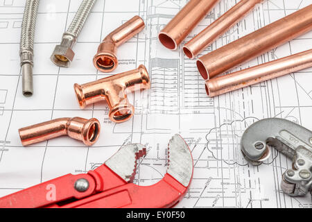 Outils de plomberie disposées sur des plans de maison, avec des tubes en cuivre Banque D'Images
