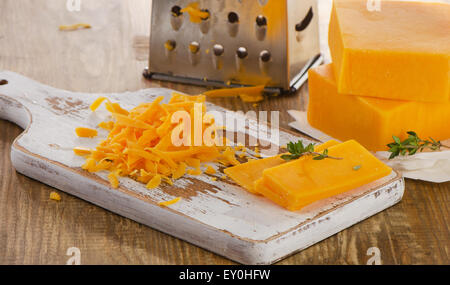 Fromage cheddar, râpé sur planche de bois. Selective focus Banque D'Images