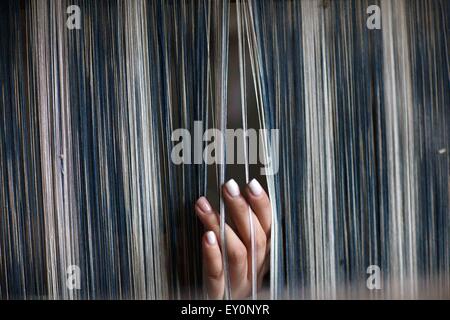 Beijing, Chine, province de Jiangsu. 15 juillet, 2015. Un étudiant vérifie les chaînes avant de tourner au Blue Calico Museum de Nantong, Province du Jiangsu en Chine de l'Est, le 15 juillet 2015. Les étudiants sont venus au Musée Calico bleu à l'expérience de faire de l'artisanat de calicot bleu pendant leurs vacances d'été. © Huang Zhe/Xinhua/Alamy Live News Banque D'Images