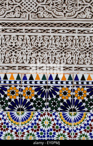 Arabesque sculptés en stuc détail mur de carreaux de céramique, à Marrakech, Maroc Banque D'Images