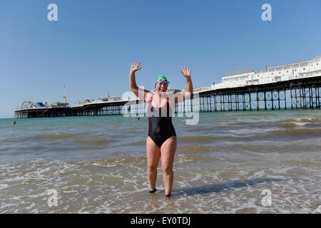 Brighton, UK. 19 juillet, 2015. Fiona l'Angleterre après le lancement de son 50k piscine défi avec une baignade autour de la jetée de Brighton tôt ce matin Fiona vise à nager 50k en 5 nages dans le pays tous les lieux en plein air dans l'eau froide de Brighton à la Lake District avant son 50e anniversaire afin de recueillir des fonds pour la charité étonner . Son fils de 11 ans Dan a le syndrome de Down a été là pour lui remonter le long de avec d'autres nageurs locaux et les membres de sa famille : Crédit Simon Dack/Alamy Live News Banque D'Images