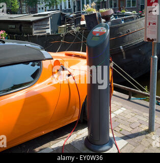 Orange lumineux de recharge pour voitures électriques Tesla station de charge publique à Amsterdam Pays-Bas Banque D'Images