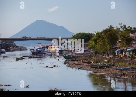 Le mont Manado Tua est vu depuis un pont qui traverse la rivière Tondano dans la zone côtière de la ville de Manado, au nord de Sulawesi, en Indonésie. Banque D'Images