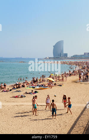 Les gens jouant sur Platya de la Barceloneta Barceloneta Beach ( ), l'hôtel W dans la distance, Barcelone Espagne Europe Banque D'Images