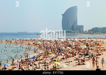 Des foules de gens en train de bronzer sur la plage de Barceloneta, Platya de la Barceloneta, avec en arrière-plan, Barcelone, Espagne Europe Banque D'Images