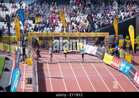 Londres, Royaume-Uni. 19 juillet, 2015. Premier à passer la ligne d'arrivée. Des milliers de coureurs participent au 10k Grande Newham Londres courir dans le parc Queen Elizabeth Olympic Park. Tous les participants ont eu la chance de terminer leur course dans le stade, avec une large audience cheering leur arrivée. Le run est le premier événement à avoir lieu dans l'ancien stade olympique depuis le début des travaux de transformation. Credit : Nathaniel Noir/Alamy Live News Banque D'Images