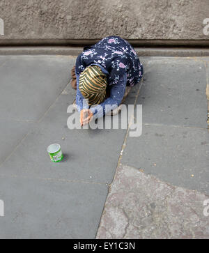 Femme agenouillée et mendier dans la rue dans le centre de Rome Banque D'Images