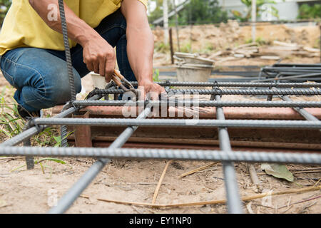 Les travailleurs sont en train de préparer des poteaux d'acier pour le bâtiment maison Banque D'Images