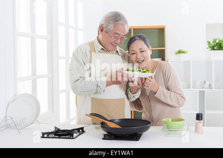 Senior couple holding un plat dans la cuisine avec le sourire ensemble, Banque D'Images