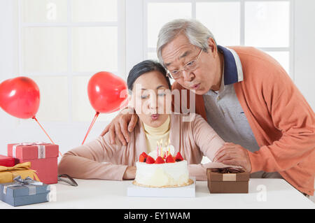 Senior couple relaxing et blowing candles ensemble, Banque D'Images