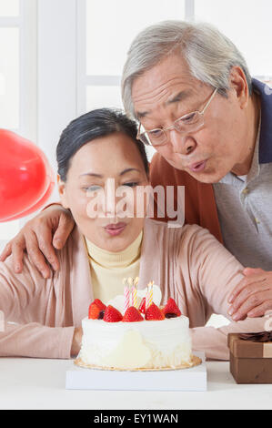 Senior couple relaxing et blowing candles ensemble, Banque D'Images