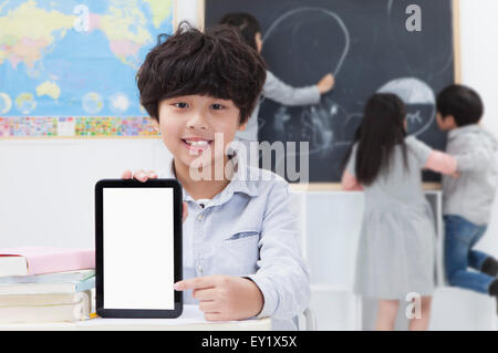 Enfants étudiant dans la classe et souriant à la caméra, Banque D'Images