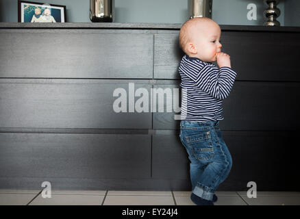 Baby Boy leaning on salon bahut Banque D'Images