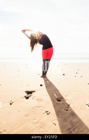 Woman in yoga pose sur plage Banque D'Images