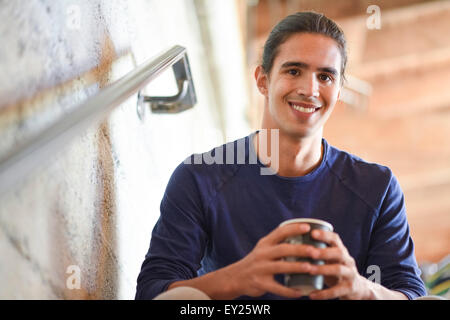 Young man holding Coffee Cup, à l'intérieur Banque D'Images