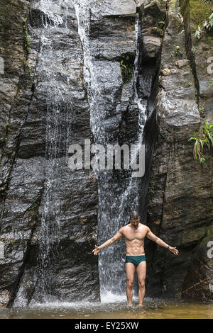 Couple à bras ouverts en face de Cascade, forêt de Tijuca, Rio de Janeiro, Brésil Banque D'Images