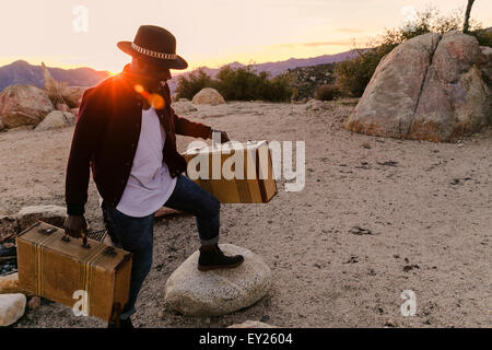 Mid adult man le déchargement des valises de voyage routier au coucher du soleil, Los Angeles, Californie, USA Banque D'Images