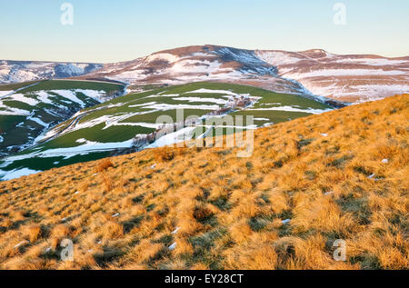 Lune s'élevant au-dessus de la lande avec des traces de la fin de l'hiver la neige. Belles couleurs de soleil du soir sur la colline. Banque D'Images