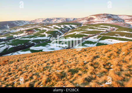 Lune s'élevant au-dessus de la lande avec des traces de la fin de l'hiver la neige. Belles couleurs de soleil du soir sur la colline. Banque D'Images