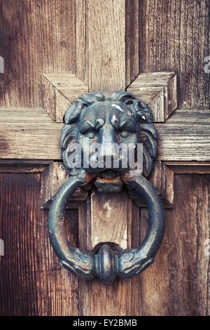 Ancienne poignée en forme de tête de lion vintage sur la porte en bois, filtre de correction tonale vintage Banque D'Images