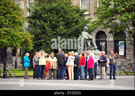 Un groupe touristique rassemble par la statue de William Edward Hartpole Lecky à Trinity College Dublin. Banque D'Images