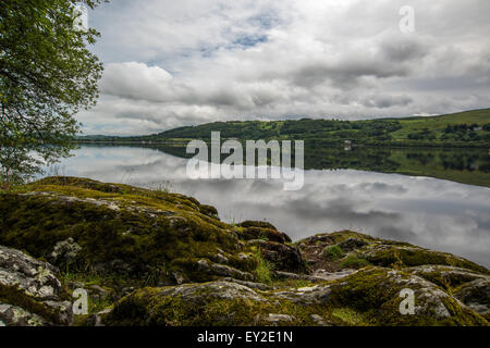 Bala Lake à la recherche sur les pierres aux reflets de nuages dans le Nord du Pays de Galles de l'eau du parc national de Snowdonia UK Juillet 2015 Banque D'Images