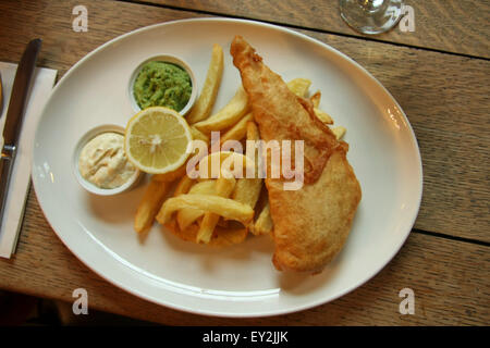 Fish & Chips anglais traditionnel avec bouillie de pois et de sauce tartare. Banque D'Images