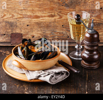 Palourdes moules dans un bol et le vin blanc sur fond de bois Banque D'Images