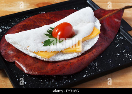 (Casabe, bammy beiju, bob, biju) - pain plat à base de manioc (tapioca) avec fromage, tomates cerise et le persil. Selective focus Banque D'Images