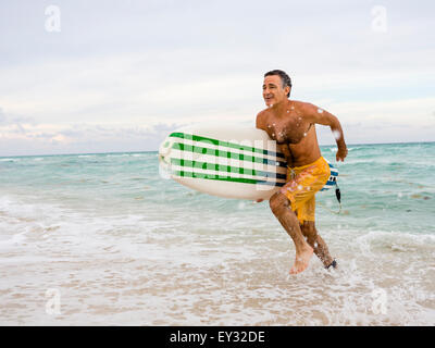 L'homme principal exécutant rapidement hors de la planche de surf la tenue d'un Banque D'Images