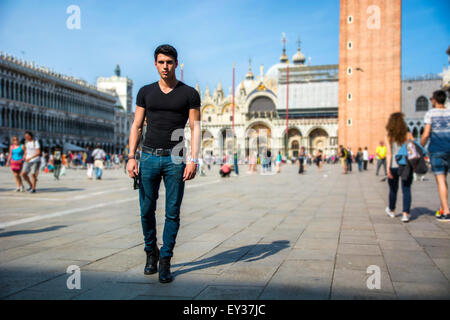 Jeune homme dans la place San Marco à Venise, Italie, portant des T-shirt noir et looking at camera Banque D'Images