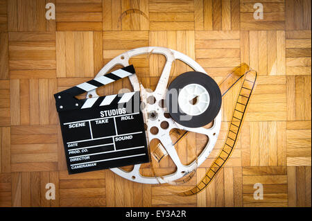 Cinema movie clapper board avec pellicule 35 mm et d'un moulinet sur plancher en bois Banque D'Images