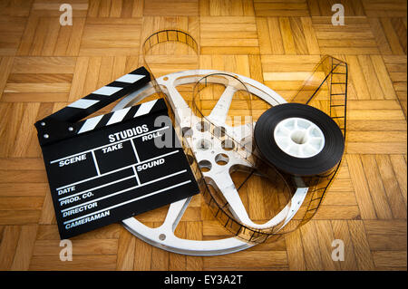 Cinema movie clapper board avec pellicule 35 mm et d'un moulinet sur plancher en bois Banque D'Images