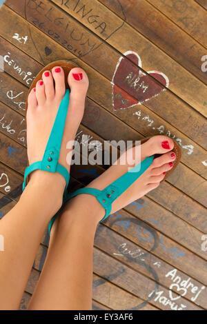 Pieds femelles portant des sandales turquoise. Banque D'Images