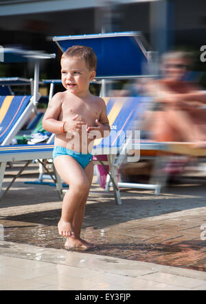 Enfant jouant dans une flaque d'eau dans la piscine Banque D'Images