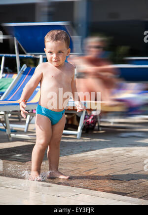 Enfant jouant dans une flaque d'eau dans la piscine Banque D'Images