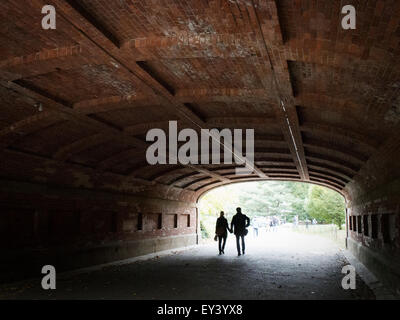 Couple marchant à travers un tunnel dans Central Park, à Manhattan. Banque D'Images