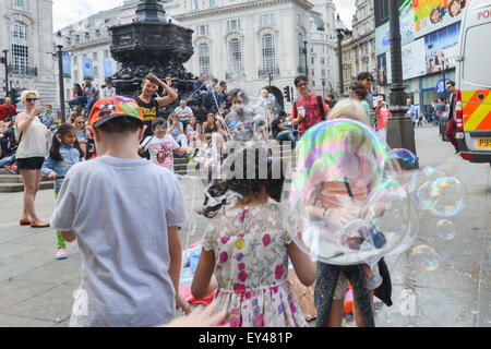 Piccadilly Circus, Londres, Royaume-Uni. 21 juillet 2015. Un homme crée des bulles de savon géantes pour amuser les enfants à Piccadilly Circus. © Ma Banque D'Images